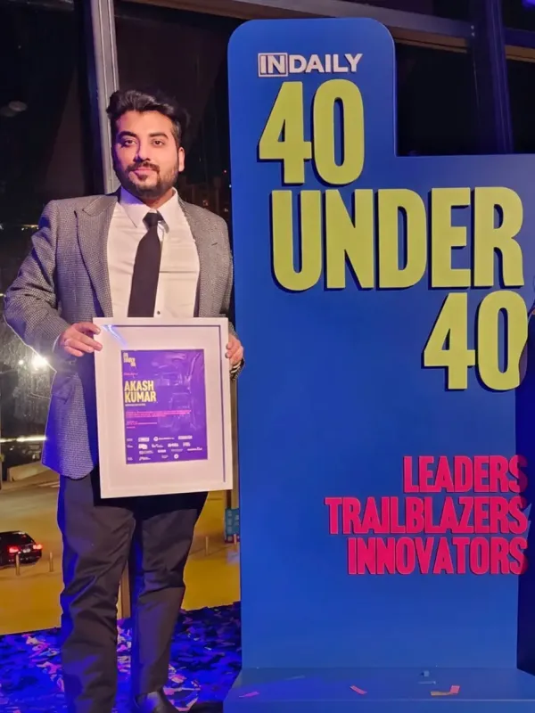 Akash Kumar holding his 40 Under 40 award